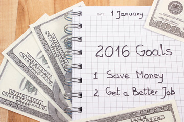Obraz premium New years resolutions written in notebook and currencies dollar