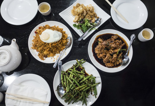 Chinese Food Table Set From Above - Green Beans, Honey Walnut Prawns, Spicy Fried Rice With Egg, Honey BBQ Beef Ribs