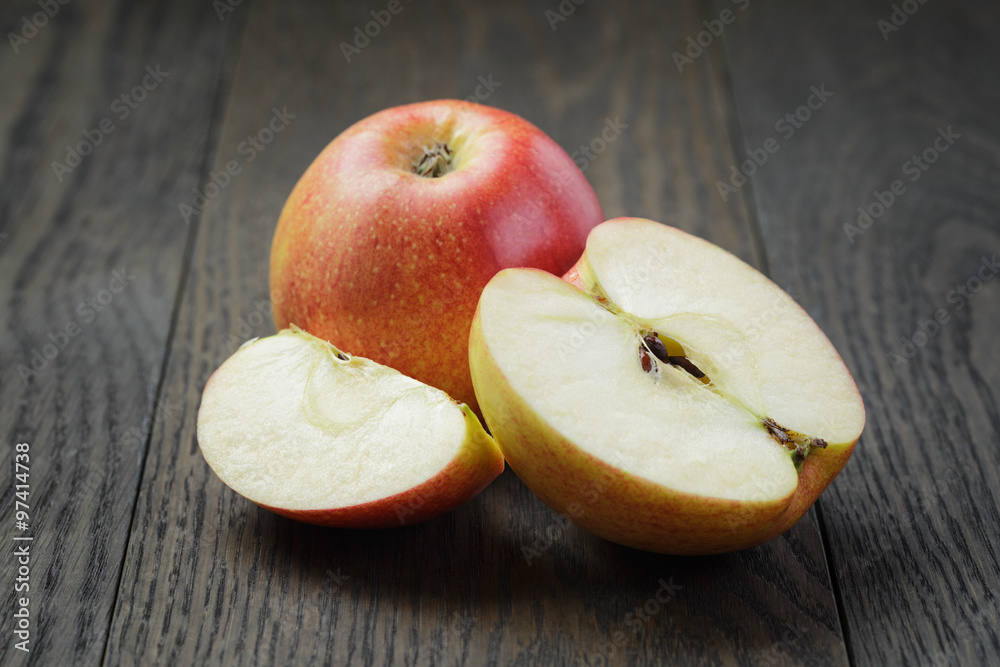 Wall mural ripe gala apples sliced on wood table