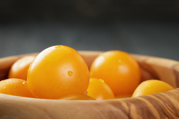 yellow cherry tomatoes in wood bowl