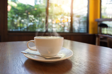 Cup of coffee on table in cafe morning light , vintage retro color effect