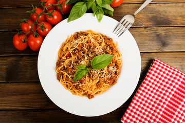 Spaghetti bolognese with cheese and basil on a plate