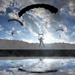 Papier peint adhésif Sports aériens Silhouette skydiver parachutist landing at sunset