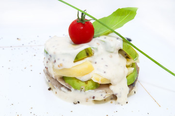 Herring salad with avocado sauce on a plate in a restaurant