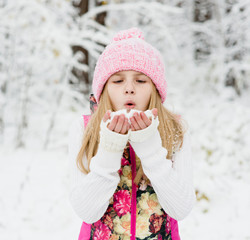 young girl blowing snow