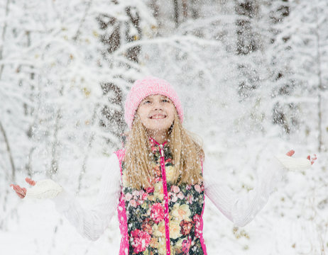 girl in winter forest enjoying snowfall