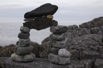 A stone tunnel with a view at the ocean on some rocks