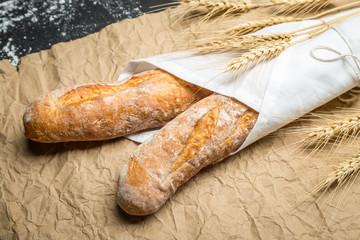 Baguette bread with wheat on paper