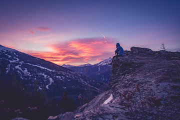 Man at the top of a mountain looking the sunrise