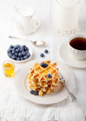 Fresh waffles with blueberries, maple syrup Breakfast table