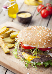 Burger, hamburger with frech fries, ketchup, mustard and fresh vegetables