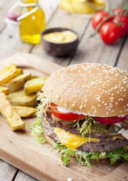 Burger, hamburger with frech fries, ketchup, mustard and fresh vegetables