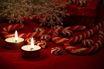 Christmas composition with red and white candy and candles