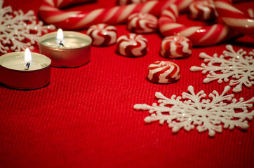 Fototapeta na wymiar Christmas composition with red and white candy and candles
