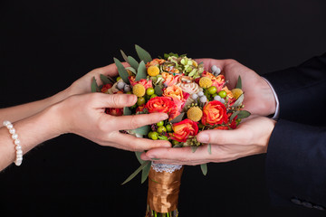 wedding bouquet in hands of the bride with wedding rings