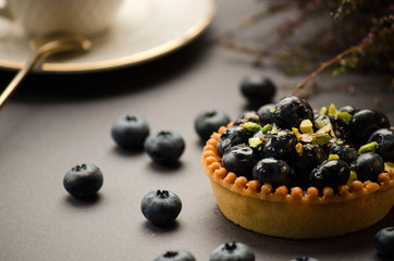 Tart with blueberries and pistachios on the table
