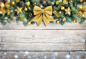 Fototapeta na wymiar Christmas Golden Ornament With Snowfall On Vintage Wooden Background