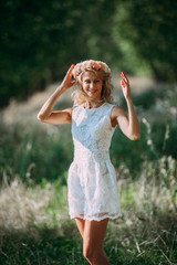 Obraz premium portrait of a beautiful sexy smiling girl with a wreath on his head in the spring park