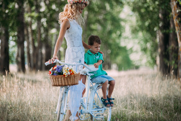Obraz premium beautiful woman rolls the baby on the big bike