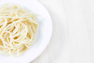Spaghetti on white dish on wooden background