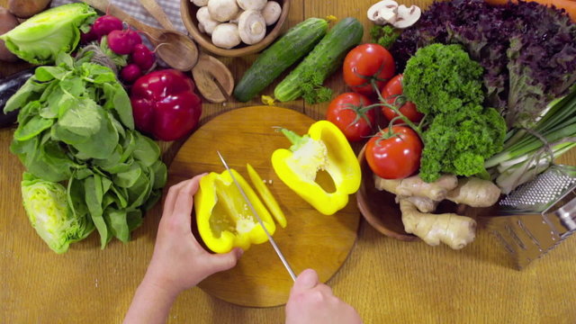 chef cutting slices of a yellow pepper slow motion