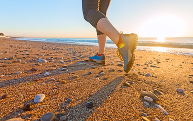 Young Woman jogging on Sand Beach along Sea Surf at Sunrise Shoes Close Up