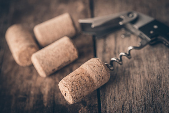 Wine cork and corkscrew on wooden table