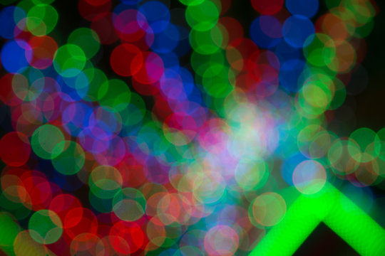 Colorfull background with christmas lights in boken.  Yellow, dark, blue and red light in Bokeh. Defocused. Festive and celebratory background. Disco lights. Laser show