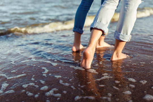 feet of couple woman and man in the sea waves