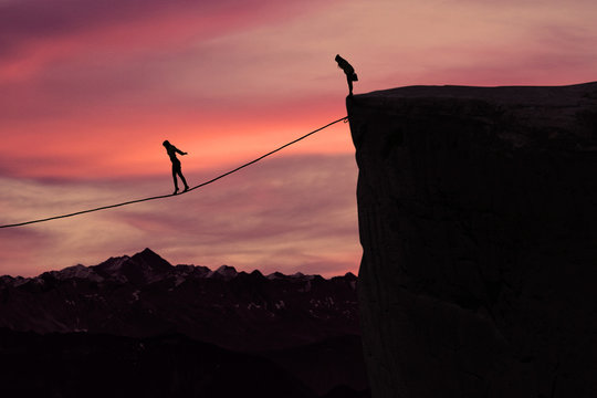 Fototapeta Woman with courage walking on the rope at mountain