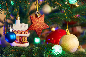 House, balls, stars and lighting garland on Christmas tree