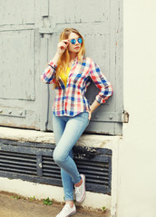 Portrait pretty young girl wearing a checkered shirt and sunglas