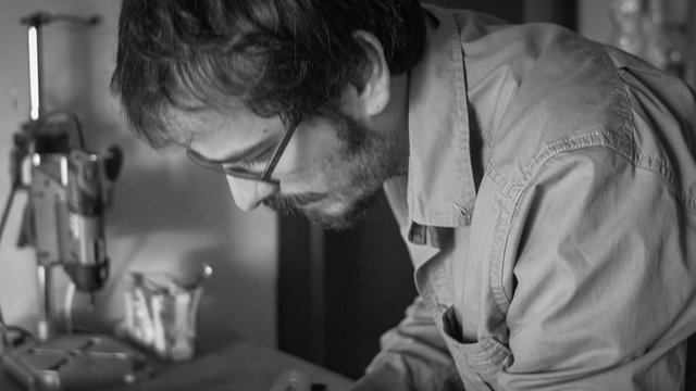 Handheld shot of Luthier making a violin