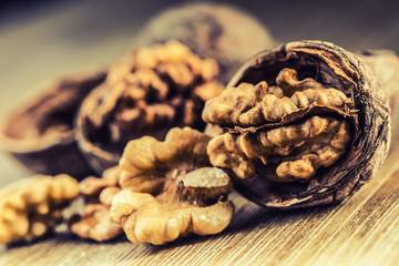Walnut kernels and whole walnuts on wooden board - Table.