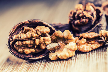 Walnut kernels and whole walnuts on wooden board - Table.