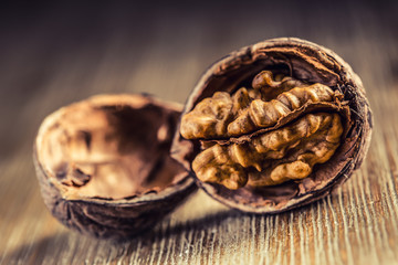 Walnut kernels and whole walnuts on wooden board - Table.