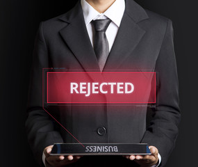 Businessman using tablet with hologram rejected text