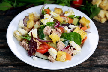 Close up Tuna salad with Spinach, rocket, red ruby chard, tomatoes, cucumbers, carrot, red onion, white chesse, croutons.
