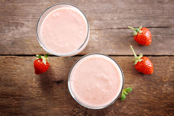 Fresh strawberry yogurt with berries around on wooden background