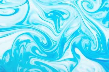 Blue ink flowing in milk texture.