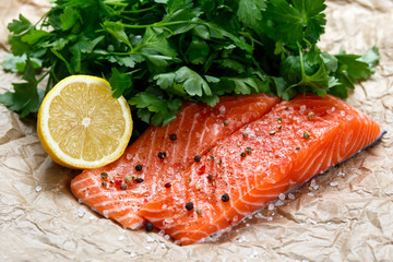 Raw Salmon fish fillet with fresh herbs on crumpled paper