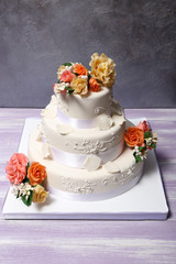 Obraz na płótnie Canvas White wedding cake decorated with flowers on grey background