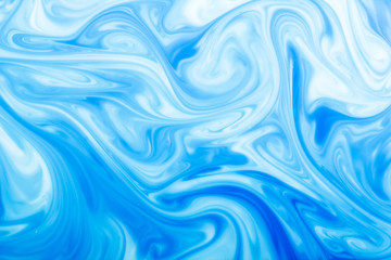 Blue ink flowing in milk texture.