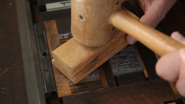 Letterpress printer makes sure his type is secure for printing.
