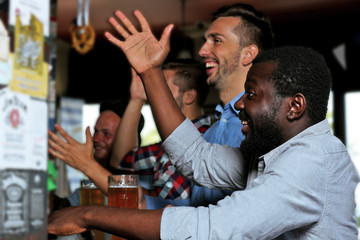 Young men drinking beer in pub