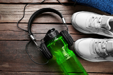 Headphones and sport equipment on old wooden background