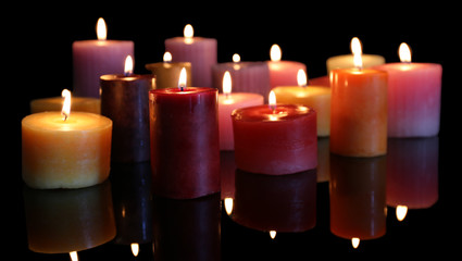 Many burning small candles on dark background