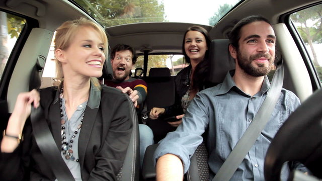 Four friends laughing driving car happy