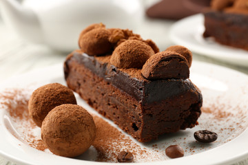 Chocolate balls and a piece of cake with walnut on the table, close-up