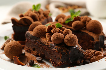 A piece of chocolate cake with walnut and mint on the table, close-up